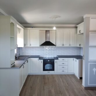 Kitchen 4 Νεοκλασική κουζίνα σε άσπρη λάκα με ταζιέρα και με παραδοσιακά πορτάκια και μαύρες λεπτομέρειες, κατασκευασμένη από το επιπλοποιείο μας Wood Design Πάτσης στην Πτολεμαΐδα.