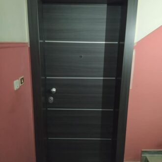Porta 2 Θωρακισμένη πόρτα σε ανθρακί απόχρωση με ίνοξ λεπτομέρειες, κατασκευασμένη από το επιπλοποιείο μας Wood Design Πάτσης στην Πτολεμαΐδα.