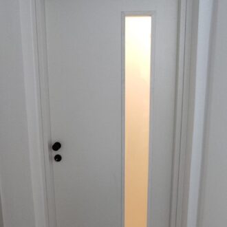 Porta 4 Εσωτερική πόρτα με φεγγίτη, σε άσπρο χρώμα με ίνοξ λεπτομέρειες, Θωρακισμένη πόρτα σε ανθρακί απόχρωση με ίνοξ και μαύρες λεπτομέρειες, κατασκευασμένη από το επιπλοποιείο μας Wood Design Πάτσης στην Πτολεμαΐδα.
